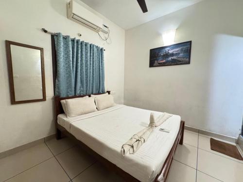 a bedroom with a bed with a blue curtain at Villa Shakthi in Pondicherry