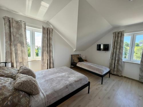 a bedroom with a bed and a tv and windows at Perła Chmielna in Chmielno