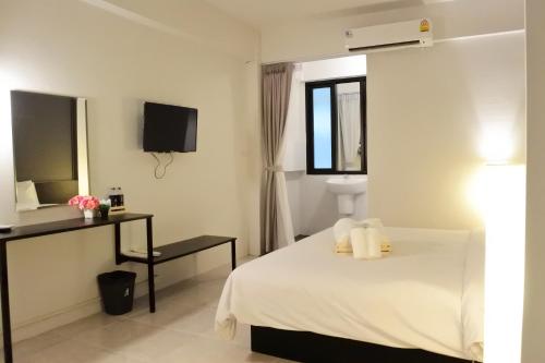 a hotel room with a bed and a television at Shane Hotel in Chiang Mai