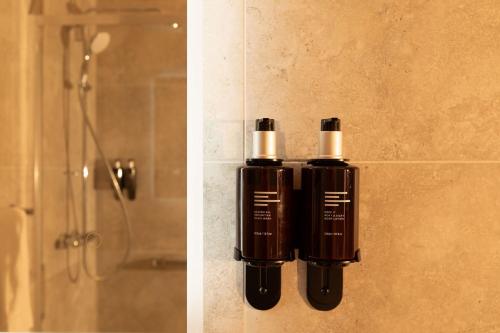 a bottle of soap on a wall next to a shower at The Address Cork in Cork