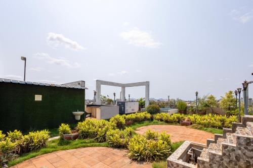a garden with plants and a green building at Hotel Aditya Grand in Guntūr
