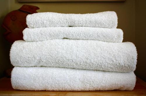 a stack of white towels sitting on a table at Britmead Guesthouse in West Bay