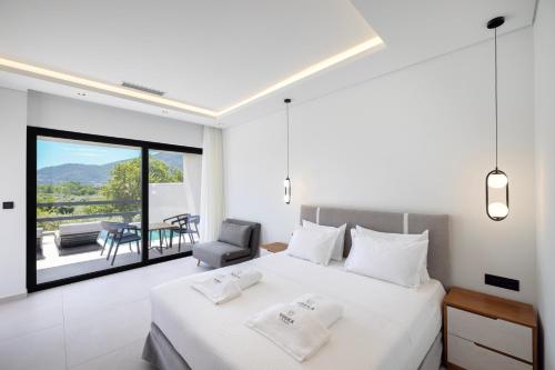 ein Schlafzimmer mit Bett, Stuhl und Balkon in der Unterkunft Toska Tower in Chrisi Ammoudia