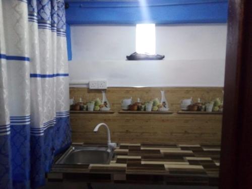a kitchen with a sink and a shower curtain at RK Guest in Nanu Oya
