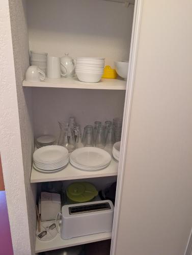 a cabinet with plates and cups and dishes in it at Cocon Luchon in Luchon