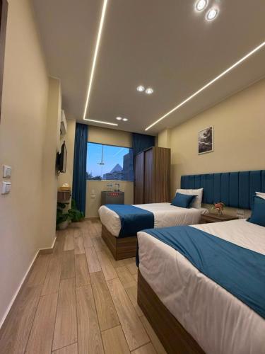 a hotel room with two beds and a window at Royal Night Pyramids View Inn in Cairo