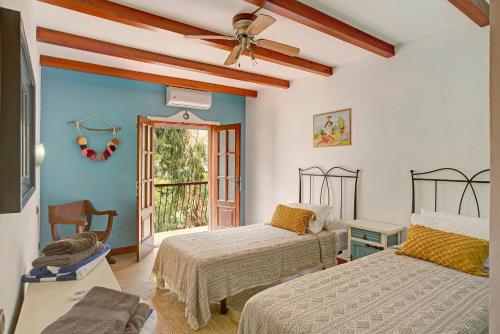a bedroom with two beds and a ceiling fan at Finca rural Los Tanquillos in San Bartolomé