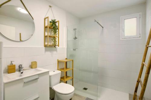 a white bathroom with a toilet and a shower at Finca rural Los Tanquillos in San Bartolomé