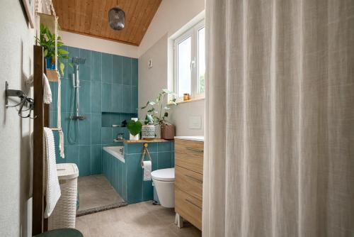 a bathroom with a toilet and a shower curtain at CasaRica Retreat in Charneca