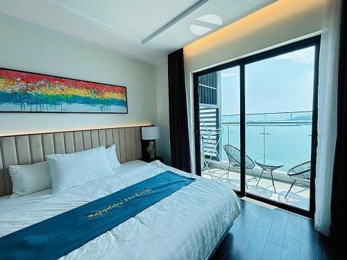 a bedroom with a bed and a view of the ocean at Sapphire Premium Studio Hạ Long in Ha Long
