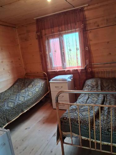 a bedroom with two beds in a wooden cabin at David traditional Oda in Shuakhevi