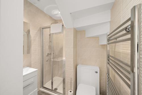 a bathroom with a toilet and a glass shower at 114 North Street in St. Andrews