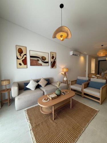 a living room with a couch and a table at The Waterfront Cabins at D-Bay - Lemon Spaces in Zāwiyat ‘Abd al Mun‘im