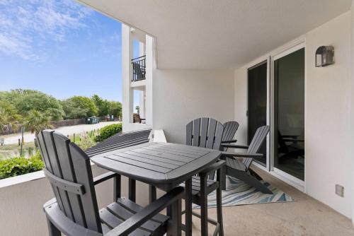 a dining room with a table and chairs on a balcony at North Breakers 201 in Saint Simons Island
