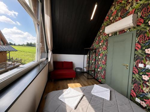 a room with a red chair and a window at D'Pazur- sauna, jacuzzi in Białka Tatrzańska