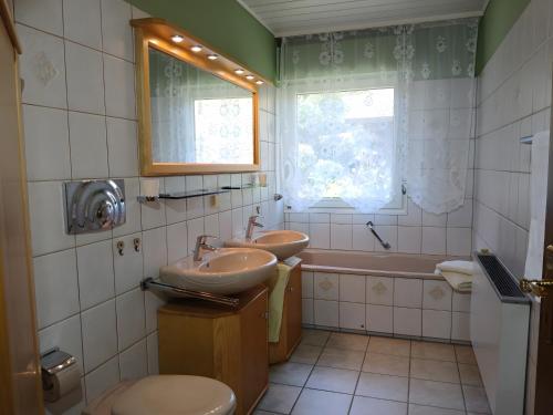 a bathroom with two sinks and a tub at FeWo Waldblick in Salzhemmendorf