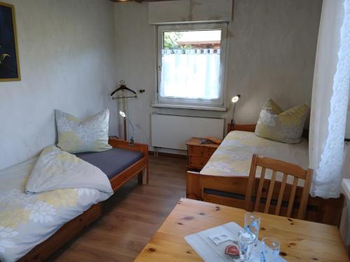 a room with two beds and a table and a window at FeWo Waldblick in Salzhemmendorf