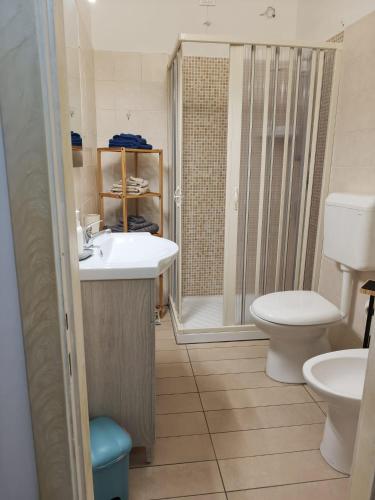 a bathroom with a toilet and a sink and a shower at Divine apartment- Schiavonea in Schiavonea