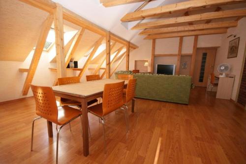 a dining room with a wooden table and chairs at Villa Bachmann - Kuršių kiemas in Juodkrantė