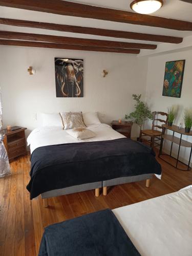 a bedroom with a large bed and wooden floors at Auberge de la Belette in Le Monestier