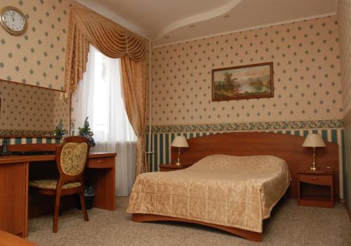 トムスクにあるSibir Hotelのベッドルーム1室(ベッド1台、デスク、椅子付)