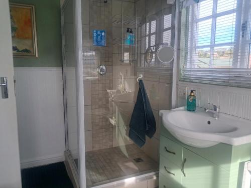 a bathroom with a shower and a sink and a sink at Franmarel in Plettenberg Bay