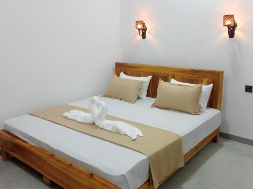 a bedroom with a bed with white towels on it at Hungry Wave in Arugam Bay
