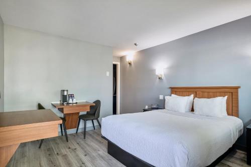 a hotel room with a bed and a desk at Motel Newstar Laval in Laval