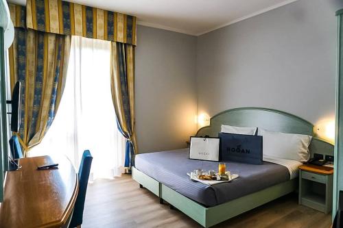 a bedroom with a bed with a table and a desk at Hotel Europa Milano in Rosate