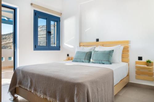 a bedroom with a bed and a window at Khōra Suites Matala in Matala