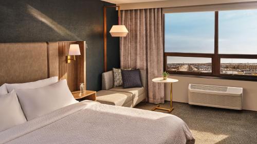 a hotel room with a bed and a couch and a window at Holiday Inn & Suites Tijuana Downtown by IHG in Tijuana