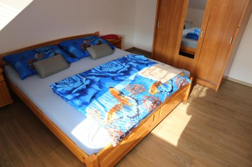a bed with a blue comforter and pillows on it at Penzion Chřiby in Staré Hutě