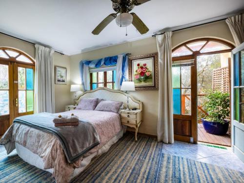 a bedroom with a bed and a ceiling fan at Aurora Guest Units in Durbanville