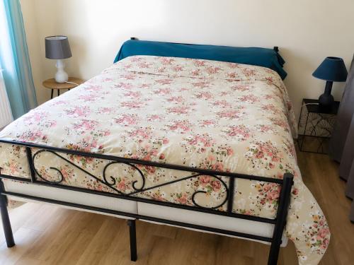 a bed with a floral comforter on it at gite 618 in Helfaut