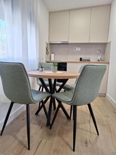 a dining room table with two chairs in a kitchen at Savo Apartments in Tivat