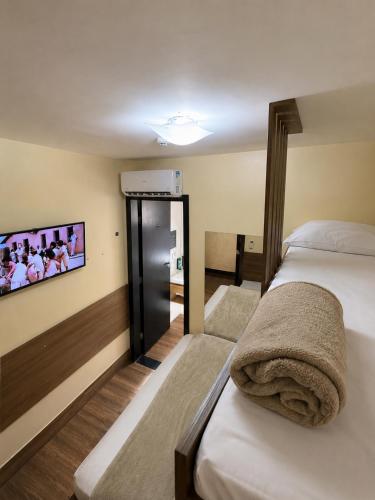 a hotel room with two beds and a flat screen tv at Uny Hotéis Brás in São Paulo