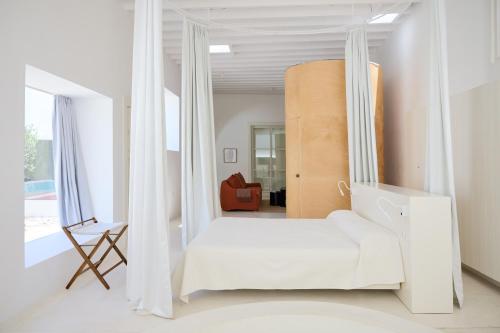 a white room with a bed and a chair at Casa Montelongo - Adults Only in La Oliva