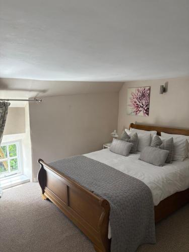 a bedroom with a large bed with white sheets and pillows at The Cottage in Sulgrave