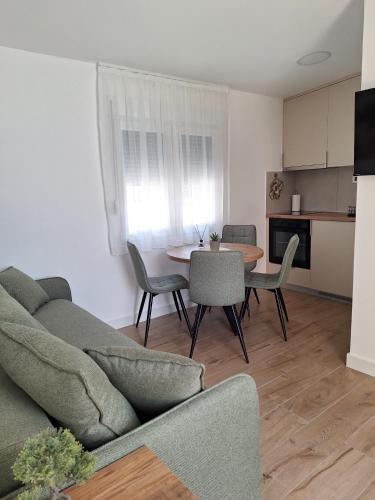 a living room with a couch and a table with chairs at Savo Apartments in Tivat