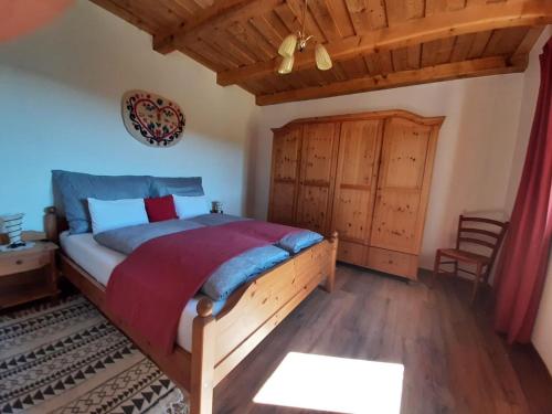 a bedroom with a wooden bed and a wooden ceiling at Jakabhegy vendégház in Szenna