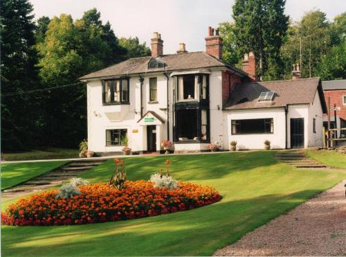 une maison blanche avec un jardin en face dans l'établissement Old Rose and Crown Hotel Birmingham, à Rubery