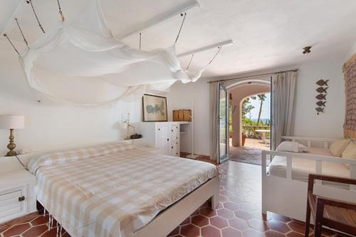 a bedroom with a large bed and a table at Villa Le Ginestre di mare in Capoliveri
