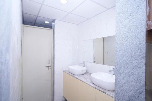 a bathroom with two sinks and a mirror at 69th Heaven Hotel in Devanhalli