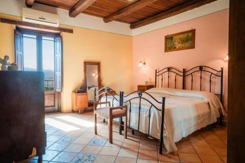 a bedroom with a bed and a chair at Tenuta la Selva Casa I Lavatoi in Casal Velino
