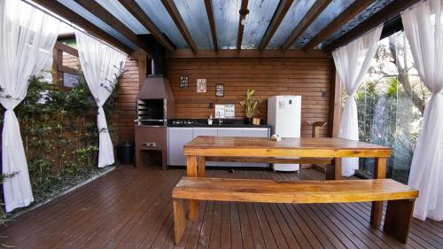 a kitchen with a wooden table and a refrigerator at Pousada Maria Eduarda in Guarda do Embaú