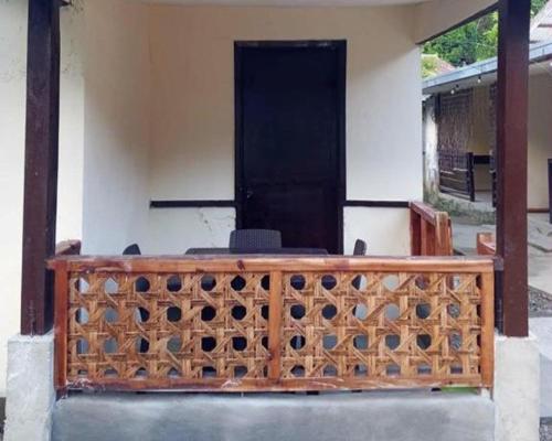 a wooden fence with a black door on a house at Bale Cabugao Cottages Rental El Nido overlooking Beach in El Nido