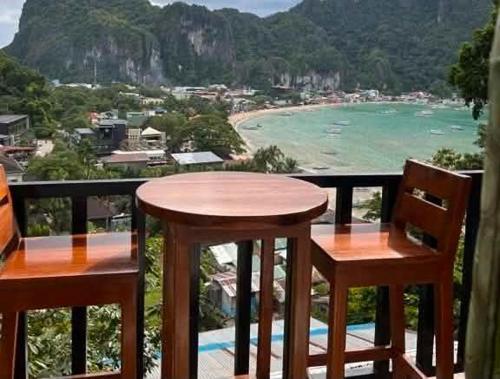 a table and chairs on a balcony with a view of the beach at Bale Cabugao Cottages Rental El Nido overlooking Beach in El Nido