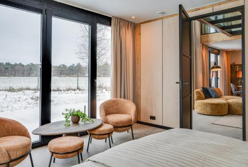 a bedroom with a bed and a table and chairs at OplooPark Forrest Villa in Oploo