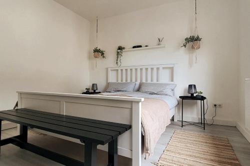 a bedroom with a bed with a bench next to it at Mosel Appartment in Briedel in Briedel