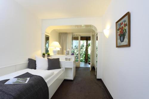 a hotel room with a bed and a mirror at Hotel Benther Berg in Ronnenberg